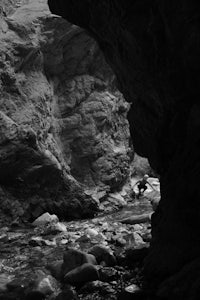 a black and white photo of a man in a canyon