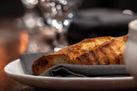 a slice of bread on a plate next to a cup of coffee