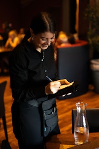 a waitress writing in a notebook