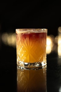 a glass of orange juice sitting on a table