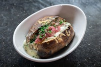 a white bowl with a stuffed potato on it