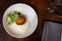 a white plate with a crab cake on it