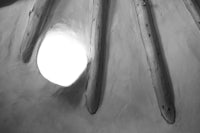 a black and white photo of a tepee with sticks in it